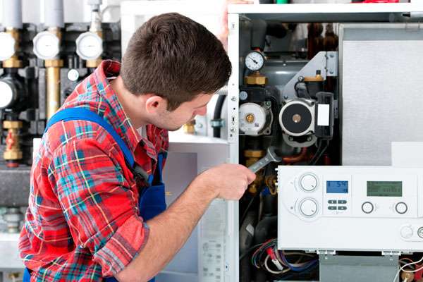Heating technician repairing boiler controls in San Carlos