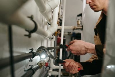 Technician inspecting commercial plumbing pipes in San Carlos