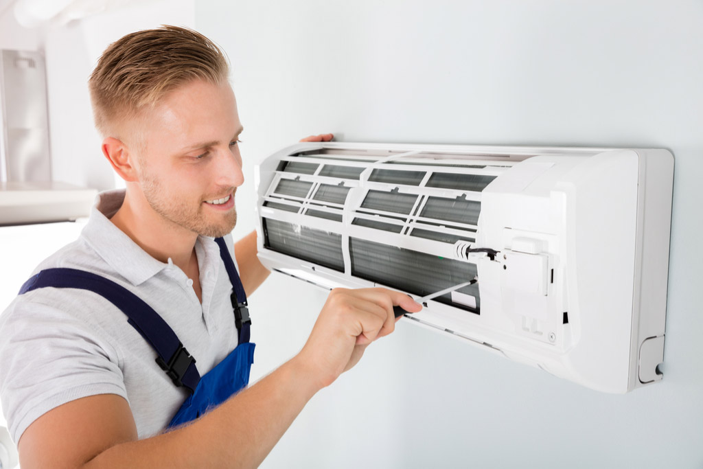 HVAC technician maintaining a ductless air conditioner in San Carlos