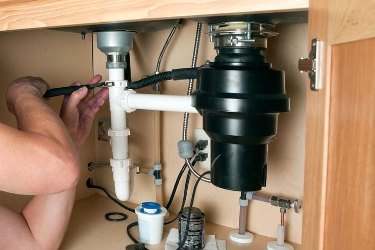 Plumber repairing a garbage disposal in San Carlos