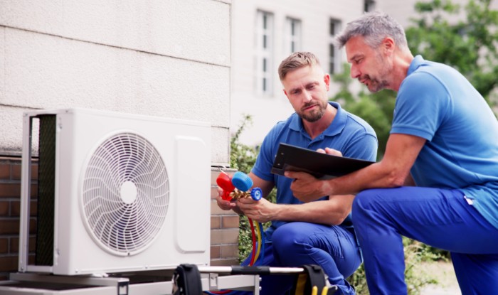 HVAC technicians installing an outdoor air conditioning unit in San Carlos